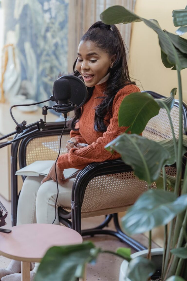 Stylish young ethnic lady recording podcast in light studio